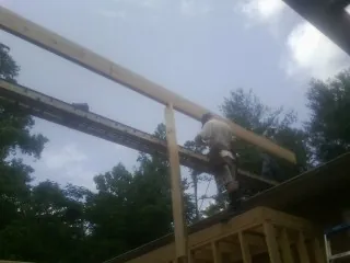 Carpenter setting a ridge beam over a new addition frame — Ice Dam Removal by Roofing Brothers in Powells Point