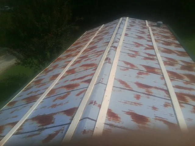 Rusted metal roof panels with new wood purlins before replacement — Storm Damage Roof Repair in Powells Point by Roofing Brothers