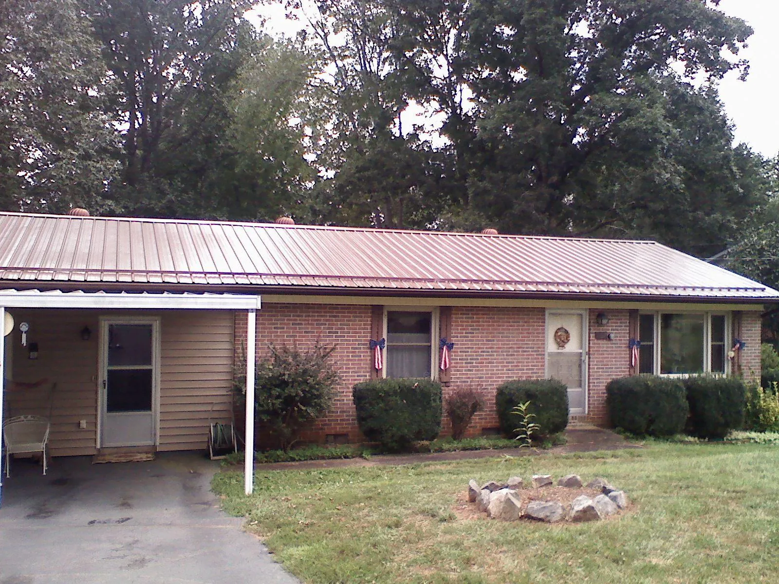 Bronze metal roof and carport on a brick ranch home — Roof Repair work by our crew in Powells Point